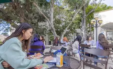 Students sitting at tables outside