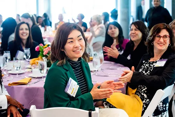 women listening smiling clapping at event