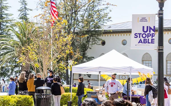 People gathered around several event booths outdoors
