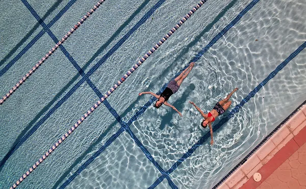 Two students swimming at the pool at the Chalon Campus