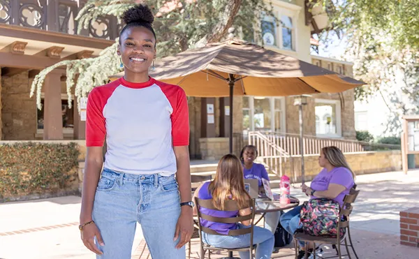 female student standing in foreground on campus