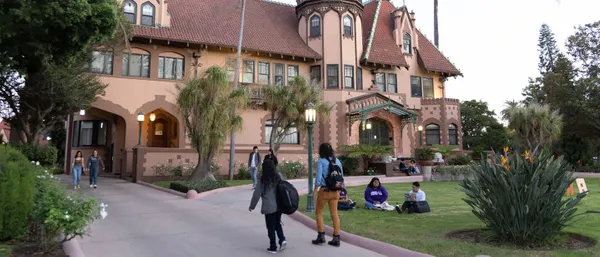 Students walking in front of the Doheny Mansion.