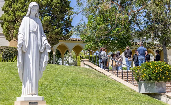 Statue of St. Mary with stairs and grass in the background