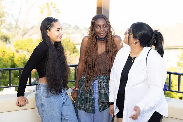 Three students talking outside