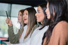 female students listening to speaker smiling and laughing