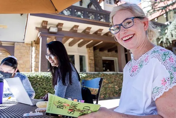 students sitting at outdoor table reading