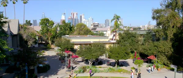 drone shot of students walking on Doheny Campus with downtown LA in the background