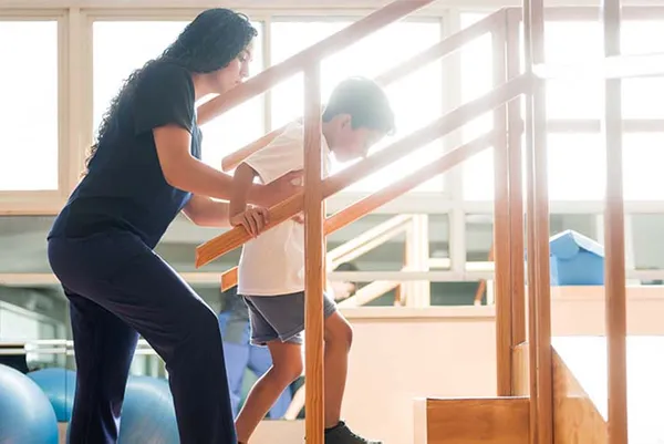 therapist helping a child walk