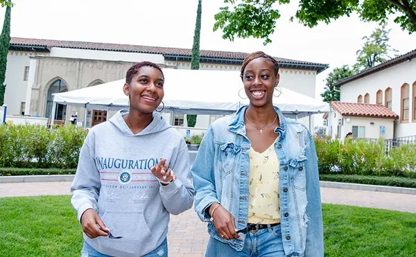 two students walking and talking on campus
