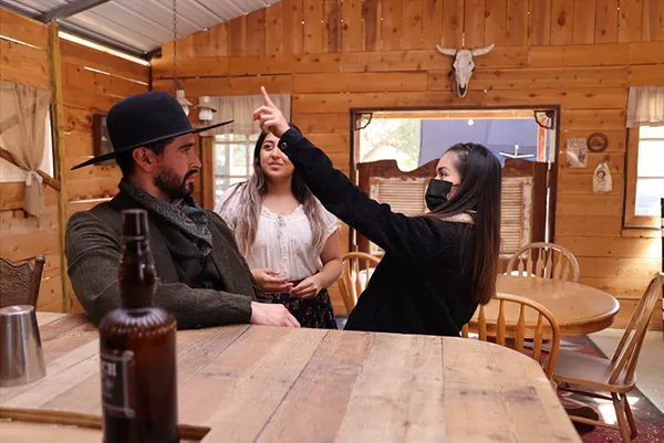 Woman pointing up on a western film set