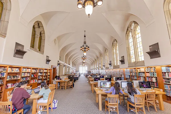 library interior shot of students working at tables and computers