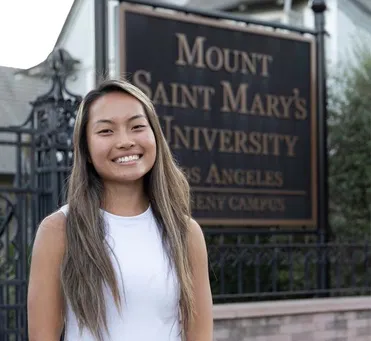 female student smiling in front of MSMU campus sign