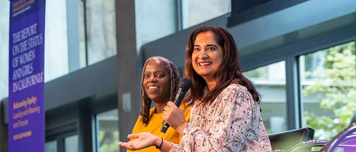 Two women on stage talking to the audience