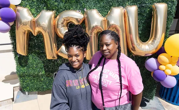 two students smiling in front of MSMU balloons