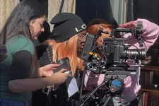 three female students working on set with a camera