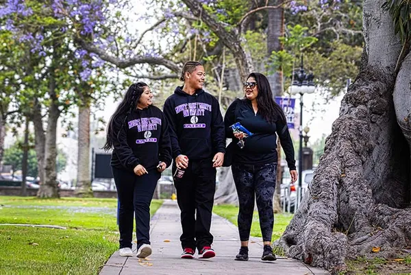 three students smiling and walking on campus in MSMU gear